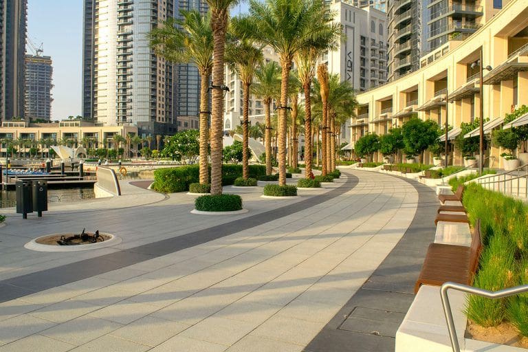 promenade with beautiful towers and green palms . Beautiful view of new modern neighborhood in Dubai