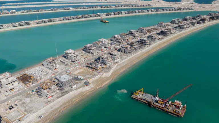 Aerial view of Palm Jebel Ali fronds showing villas at various construction stages with marine works in progress