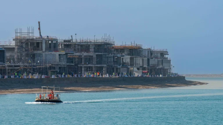 Palm Jebel Ali beachfront villa under construction with scaffolding and workers on site